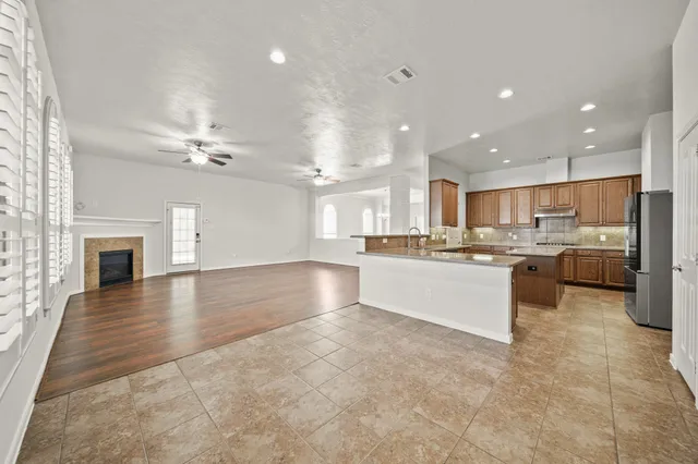a large white kitchen with a large window and kitchen view