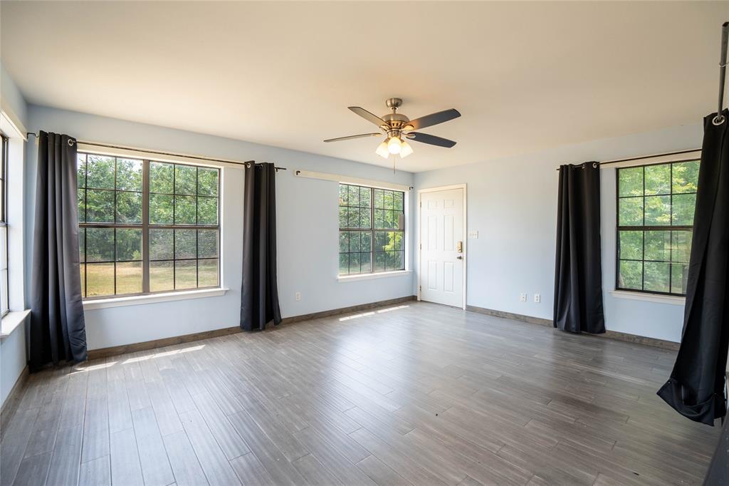 909 Fox Lane Azle, TX 76020 - Photo 11 of 13 a view of an empty room with a window and wooden floor