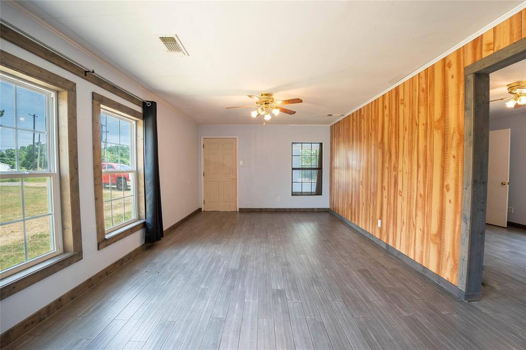909 Fox Lane Azle, TX 76020 - Photo 4 of 13 an empty room with wooden floor and windows
