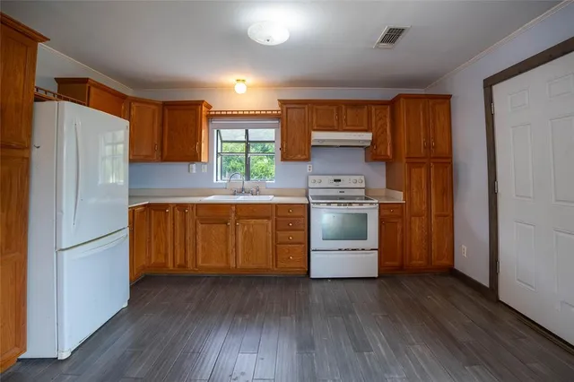 a kitchen with a stove a refrigerator and a sink