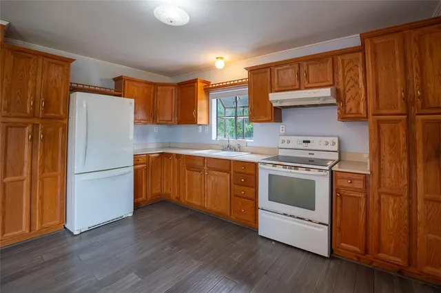 a kitchen with a refrigerator sink and cabinets