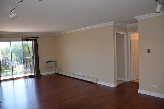 1567 Ridge Avenue, Unit 503 Evanston, IL 60201 - Photo 9 of 17 an empty room with wooden floor and windows with curtains