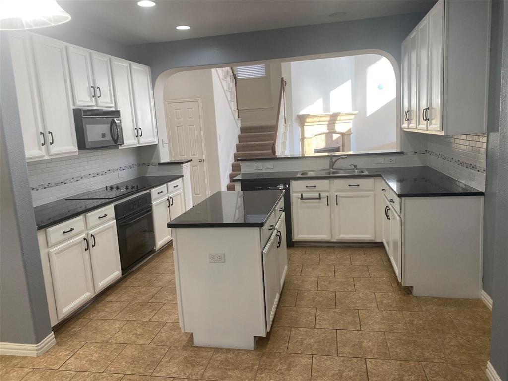 612 Catalpa Road Fort Worth, TX 76131 - Photo 12 of 26 a kitchen with stainless steel appliances granite countertop a stove a sink and a microwave