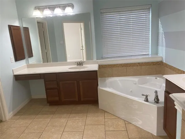 a bathroom with a bathtub sink and mirror