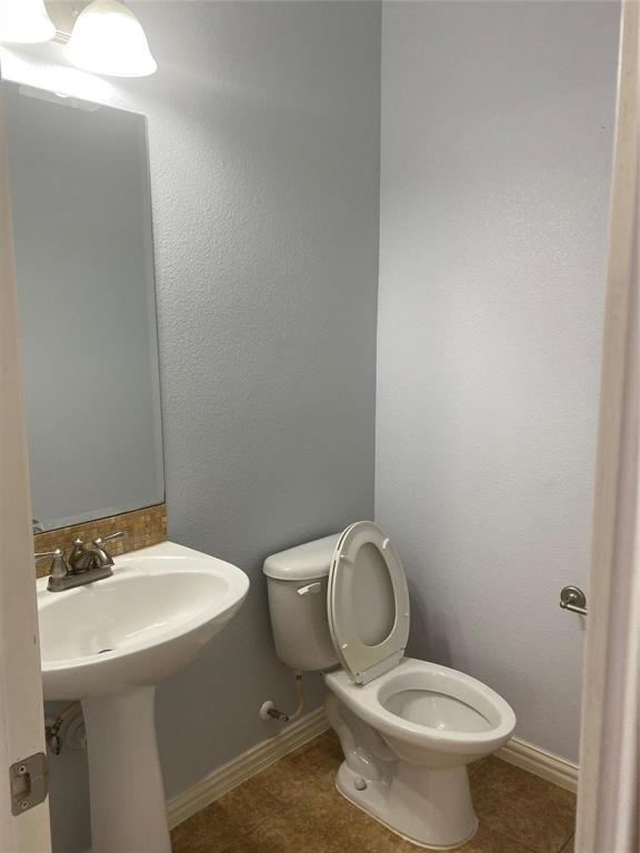 612 Catalpa Road Fort Worth, TX 76131 - Photo 20 of 26 a white toilet sitting next to a bathroom sink