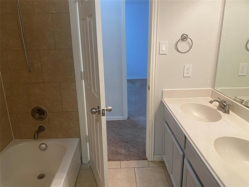 612 Catalpa Road Fort Worth, TX 76131 - Photo 24 of 26 a bathroom with a granite countertop sink a mirror and shower