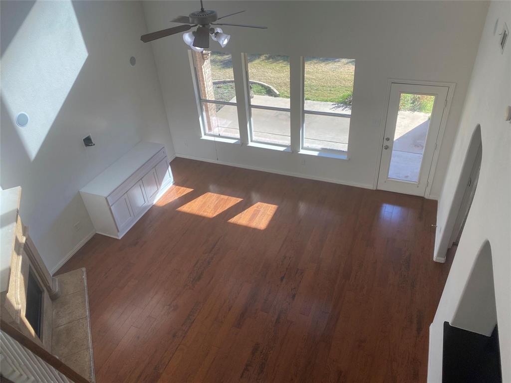 612 Catalpa Road Fort Worth, TX 76131 - Photo 9 of 26 a view of an empty room with wooden floor and a window
