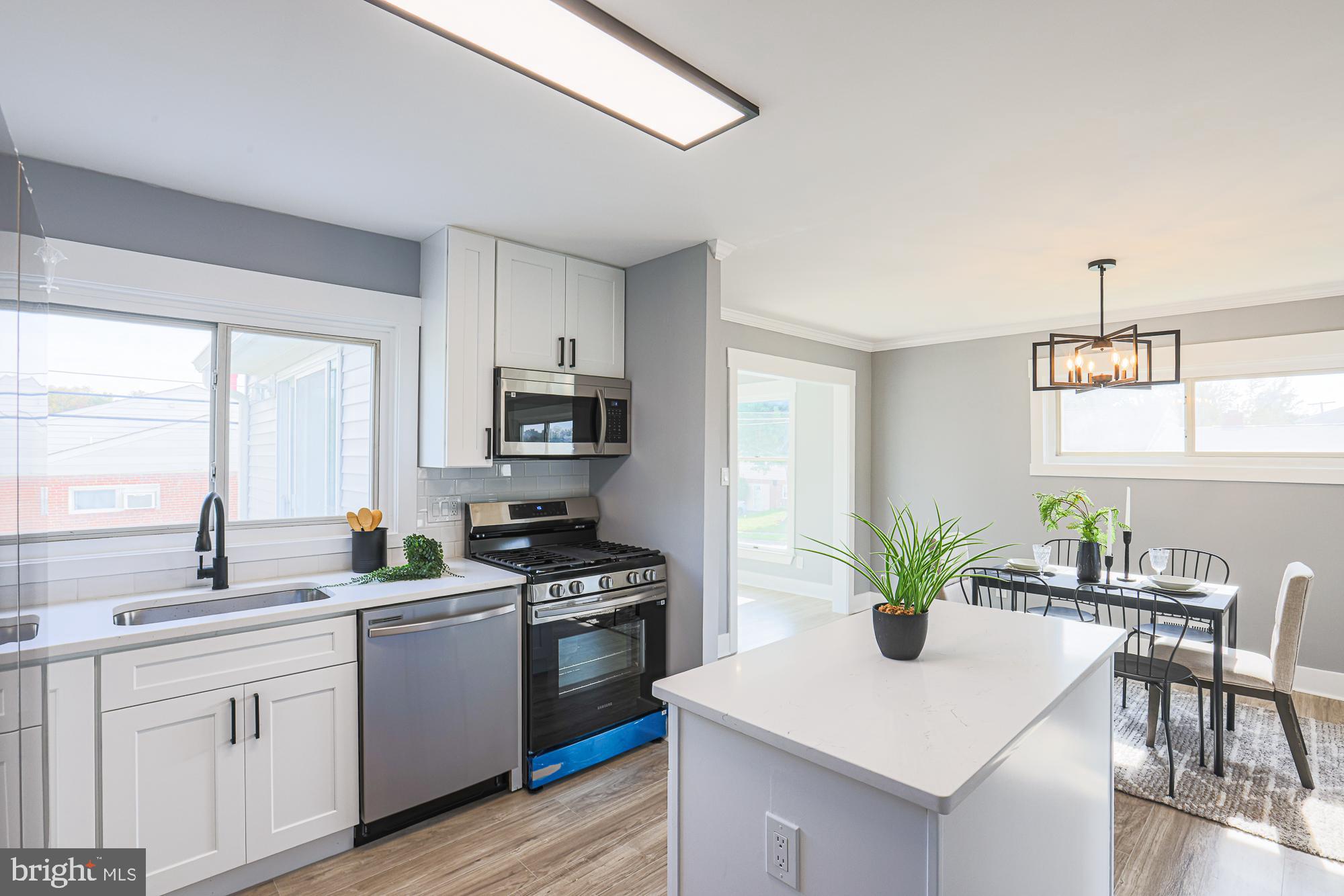 3715 Washington Avenue Baltimore, MD 21244 - Photo 22 of 57 a kitchen with white cabinets stainless steel appliances and a window
