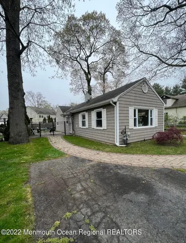 a view of a yard in front of a house with large trees