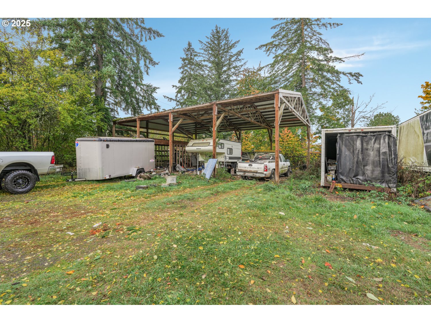 19807 Highway 211 Colton, OR 97017 - Photo 21 of 22 a view of a backyard with table and chairs a barbeque and a large window