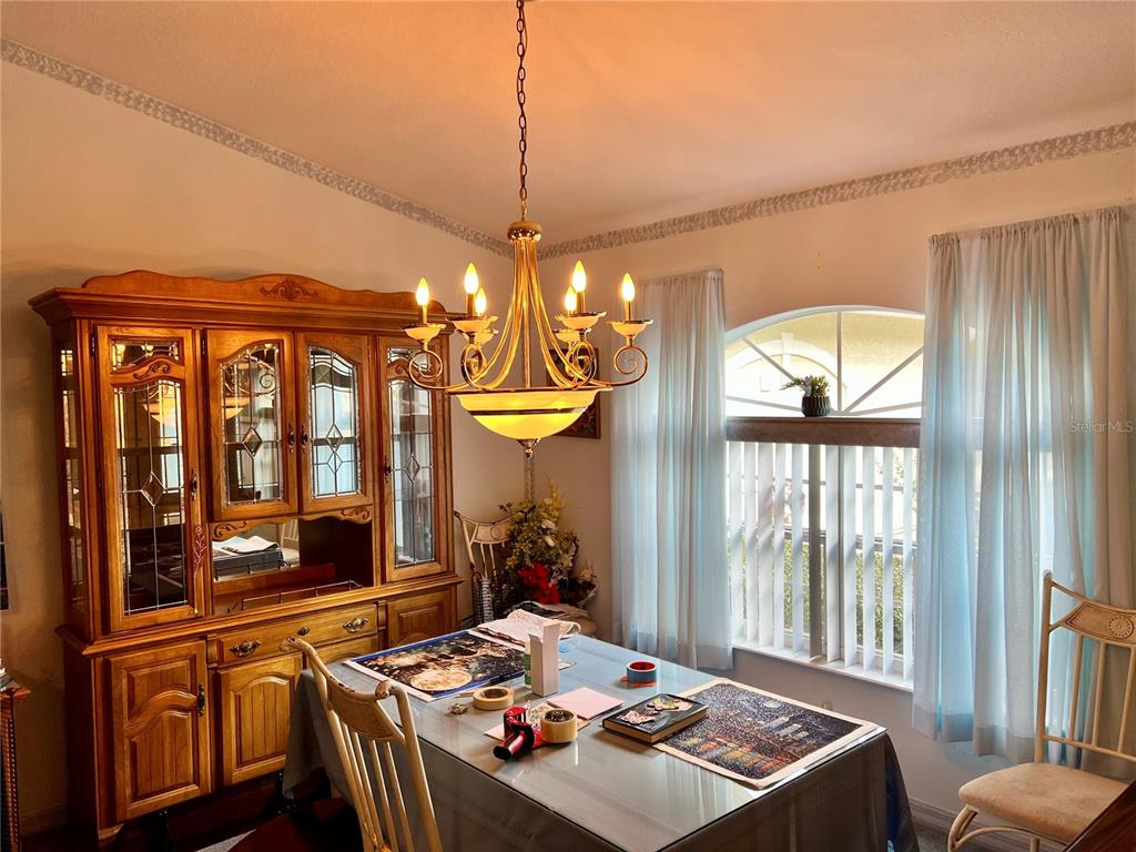 1995 East Newhaven Street Inverness, FL 34453 - Photo 13 of 48 a view of a dining room with furniture a chandelier and large windows