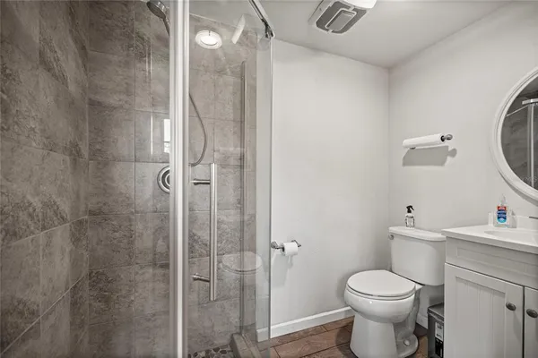 a bathroom with a toilet sink vanity and shower