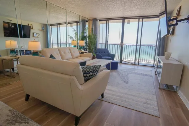 a living room with furniture a flat screen tv and kitchen view
