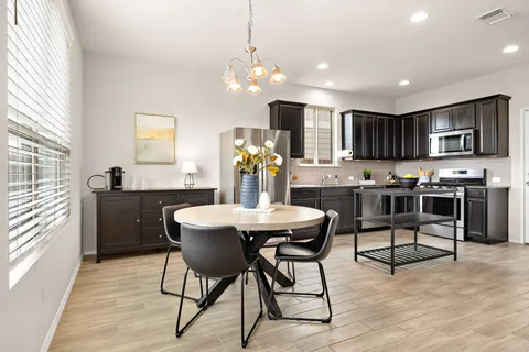 a kitchen with stainless steel appliances kitchen island granite countertop a refrigerator a stove a sink dishwasher with a dining table and chairs