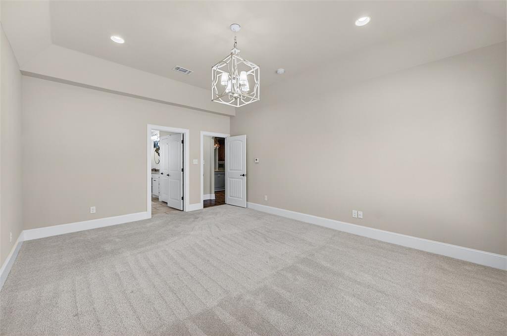 2420 Remuda Drive Sherman, TX 75092 - Photo 17 of 40 an empty room with a fireplace and chandelier