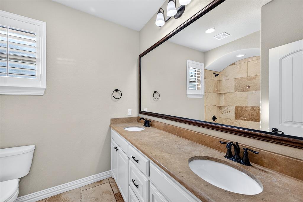 2420 Remuda Drive Sherman, TX 75092 - Photo 28 of 40 a bathroom with a granite countertop sink mirror and a toilet