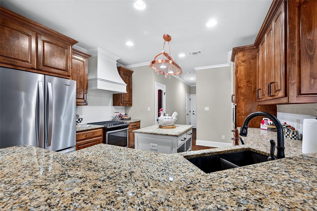 2420 Remuda Drive Sherman, TX 75092 - Photo 8 of 40 a kitchen with stainless steel appliances kitchen island granite countertop a sink stove and refrigerator
