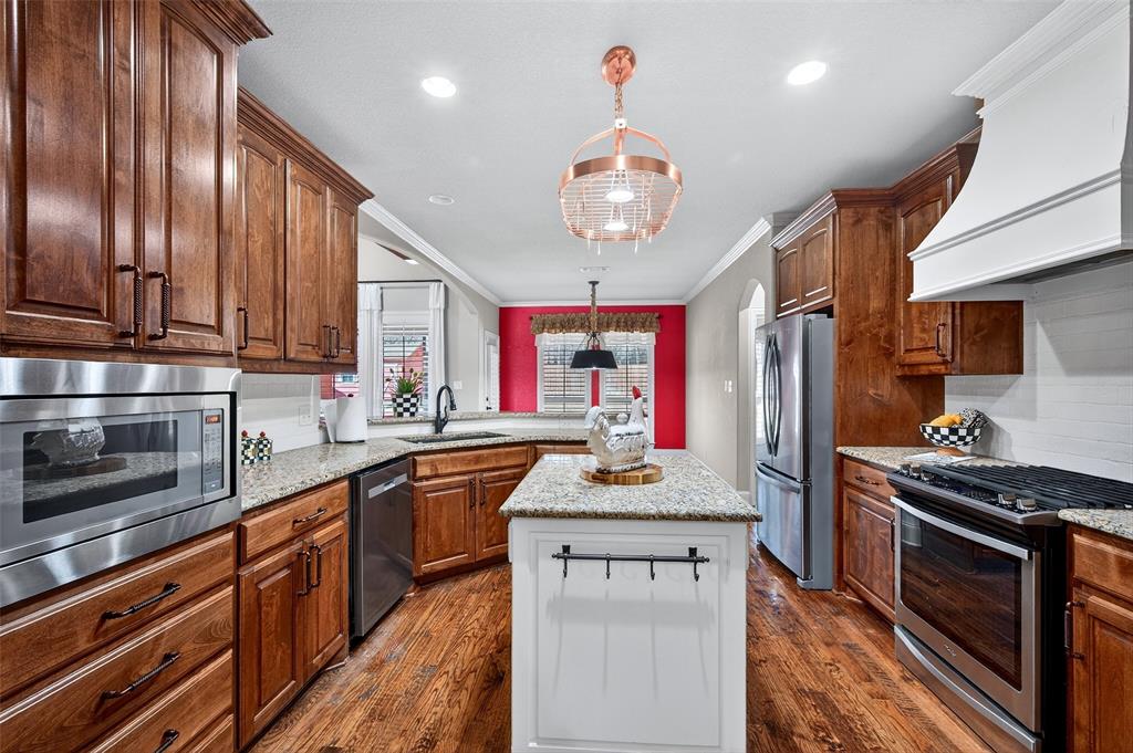 2420 Remuda Drive Sherman, TX 75092 - Photo 10 of 40 a kitchen with kitchen island granite countertop stainless steel appliances cabinets a sink and a counter space