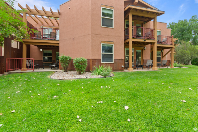 100 West 200 South, Unit 118 Moab, UT 84532 - Photo 26 of 39 Back of property with a patio, stucco siding, a yard, and a pergola