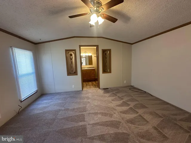 a view of an empty room with a chandelier fan