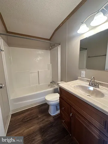 a bathroom with a bathtub shower sink vanity mirror and toilet