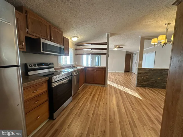a kitchen with stainless steel appliances wooden floors and wooden cabinets