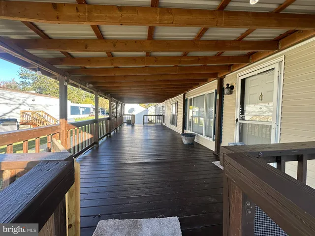 a view of an empty room with wooden floor and windows