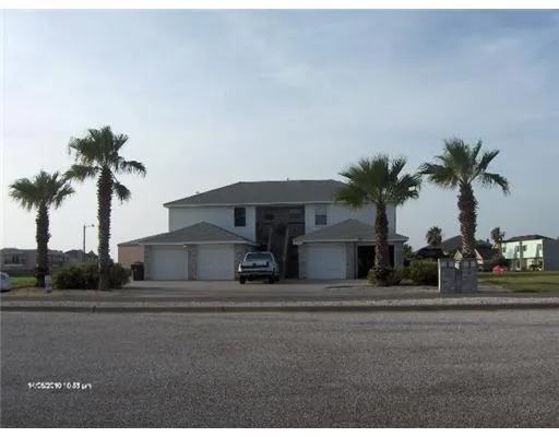 a front view of house with yard and palm tree