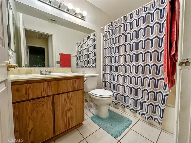 a bathroom with a sink a toilet and shower curtain