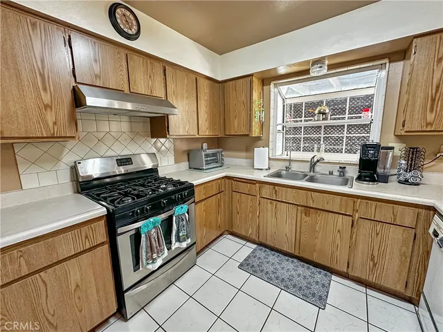 a kitchen with granite countertop a stove sink and cabinets