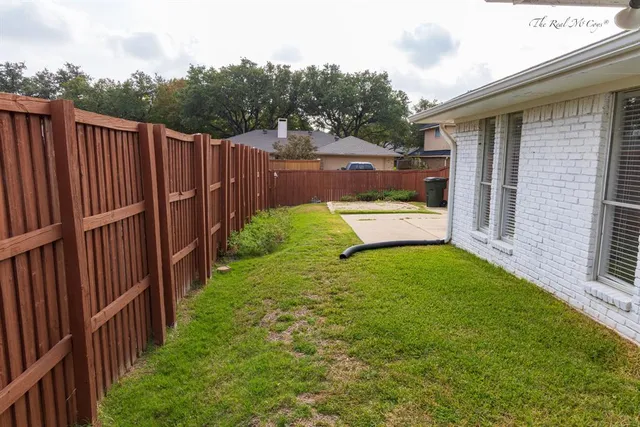 a view of a backyard with wooden fence
