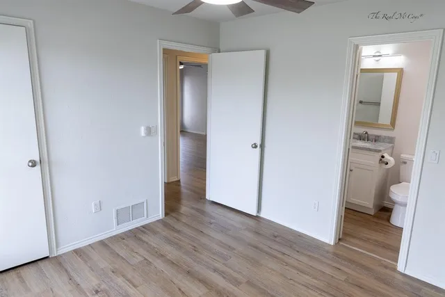 a view of a room with wooden floor and a bathroom