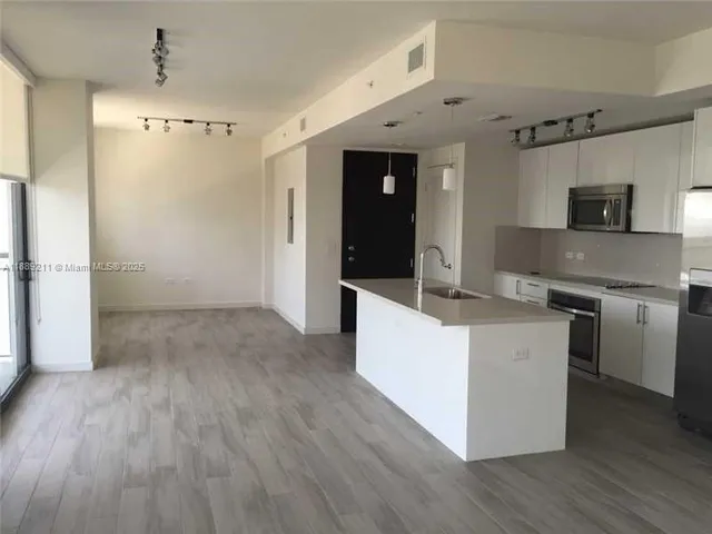 a large kitchen with cabinets and stainless steel appliances