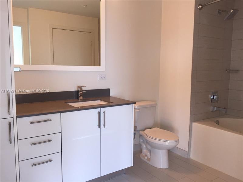999 Southwest 1st Avenue, Unit 2103 Miami, FL 33130 - Photo 6 of 16 a bathroom with a sink a toilet and bathtub