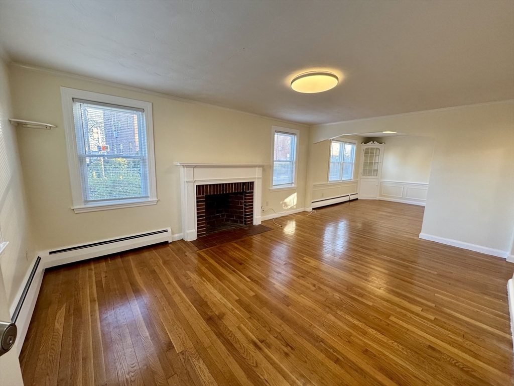 40 Gardner Street, Unit 1 Boston, MA 02132 - Photo 1 of 8 an empty room with wooden floor and windows