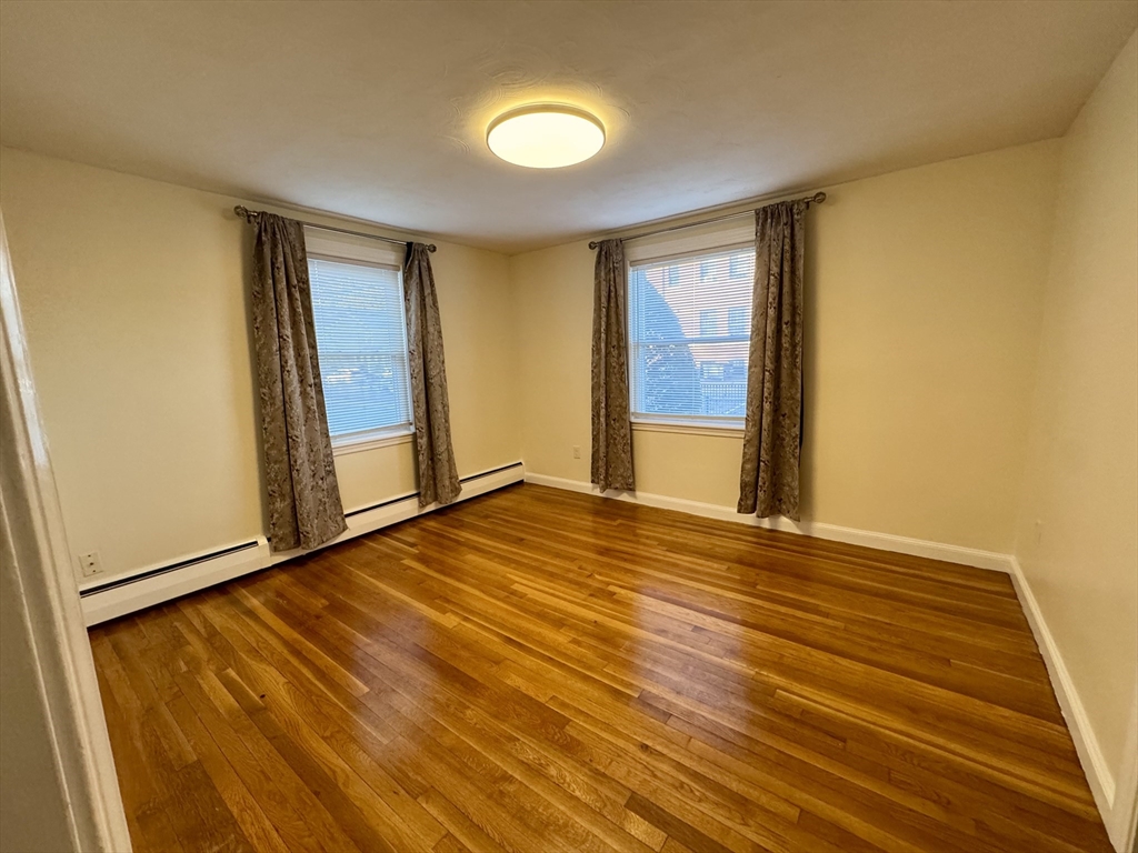 40 Gardner Street, Unit 1 Boston, MA 02132 - Photo 7 of 8 a view of an empty room with wooden floor and a window