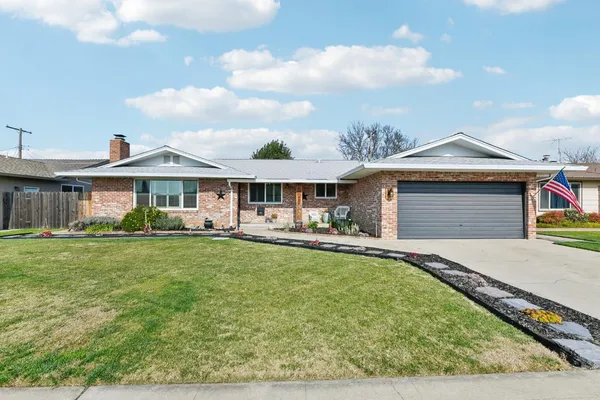 a front view of a house with a garden and patio