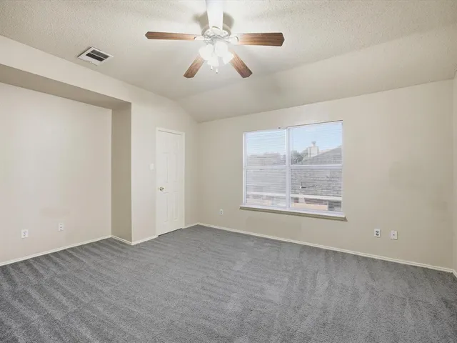 a view of an empty room with chandelier fan