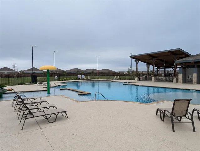 a swimming pool with outdoor seating and yard
