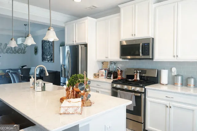 a kitchen with kitchen island granite countertop a sink stainless steel appliances and cabinets
