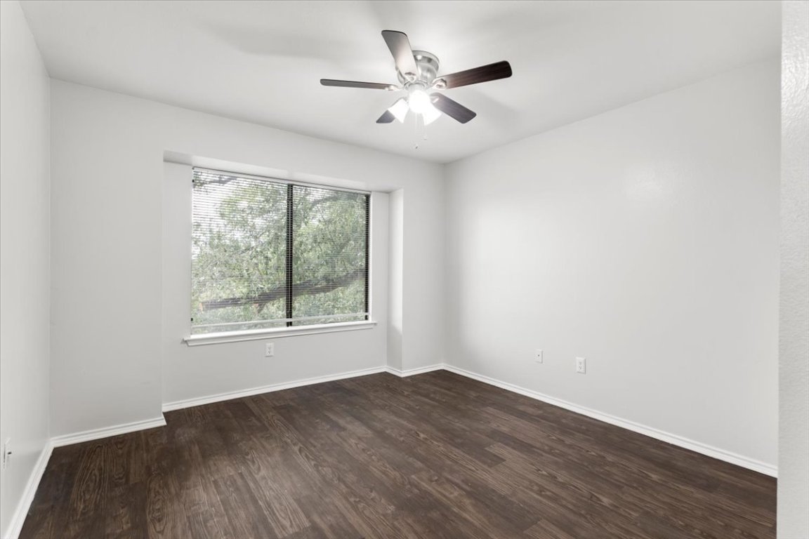 1740 Timber Ridge Road, Unit 132 Austin, TX 78741 - Photo 14 of 29 an empty room with wooden floor and windows