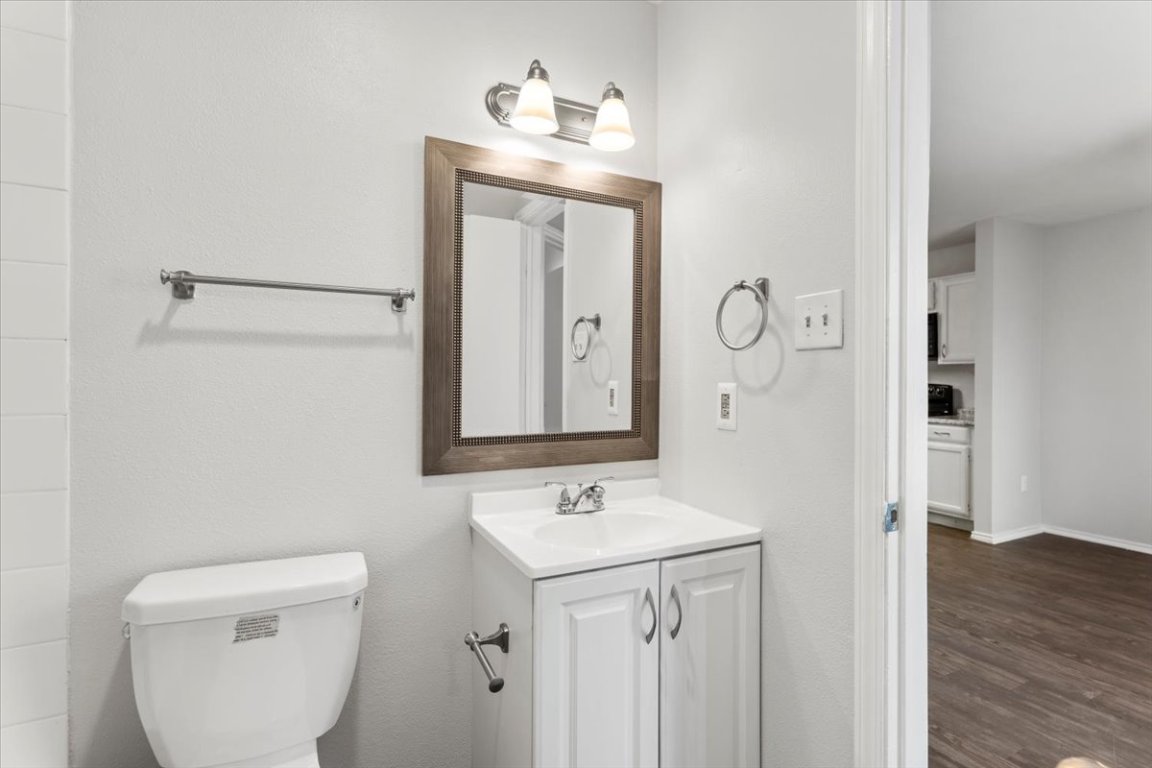 1740 Timber Ridge Road, Unit 132 Austin, TX 78741 - Photo 21 of 29 a bathroom with a toilet a sink and mirror