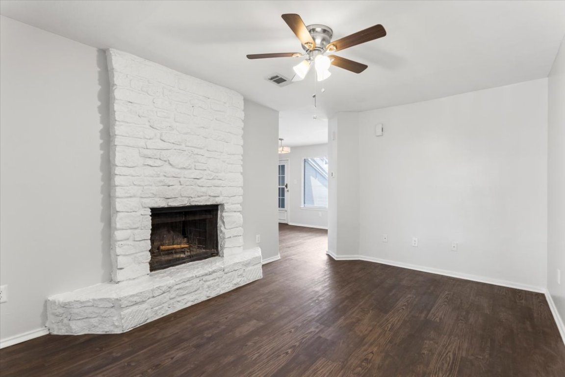 1740 Timber Ridge Road, Unit 132 Austin, TX 78741 - Photo 5 of 29 a view of a livingroom with a fireplace a ceiling fan and wooden floor