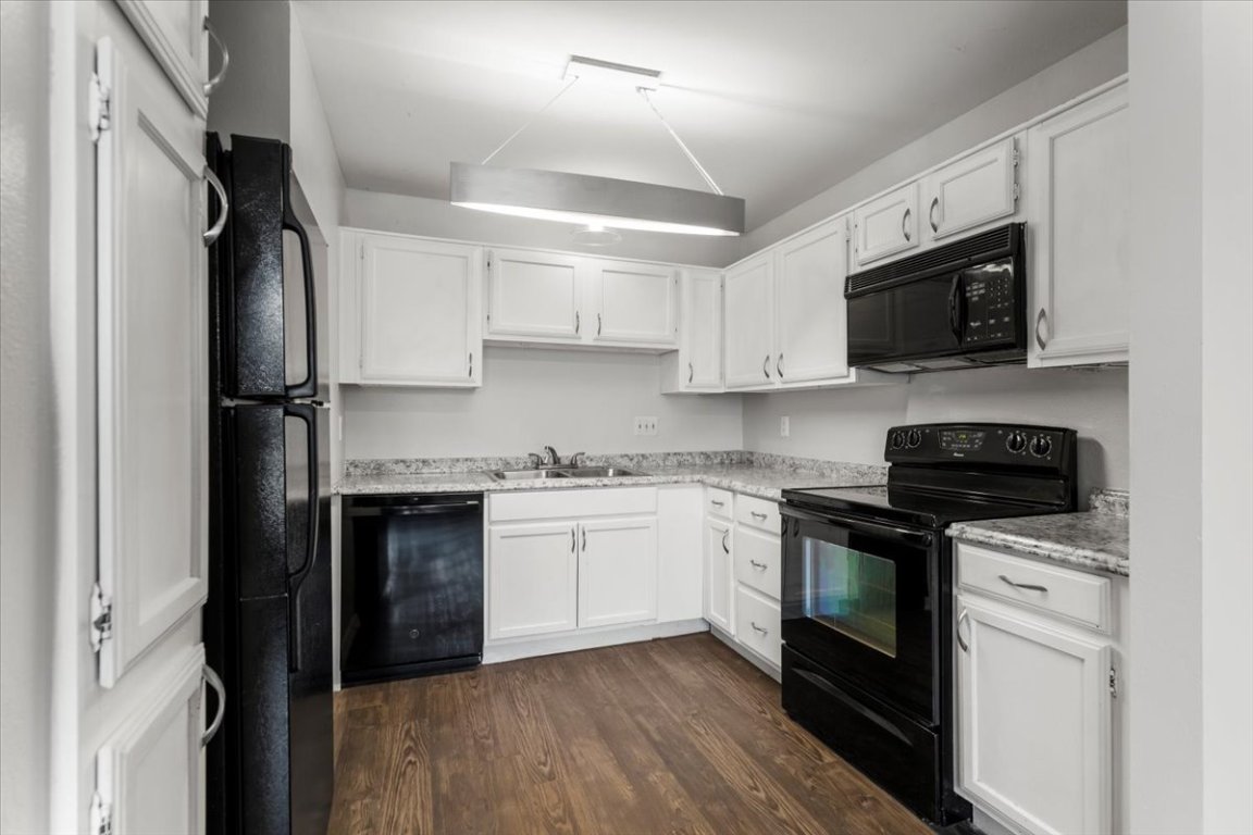 1740 Timber Ridge Road, Unit 132 Austin, TX 78741 - Photo 8 of 29 a kitchen with stainless steel appliances granite countertop a stove sink microwave and refrigerator
