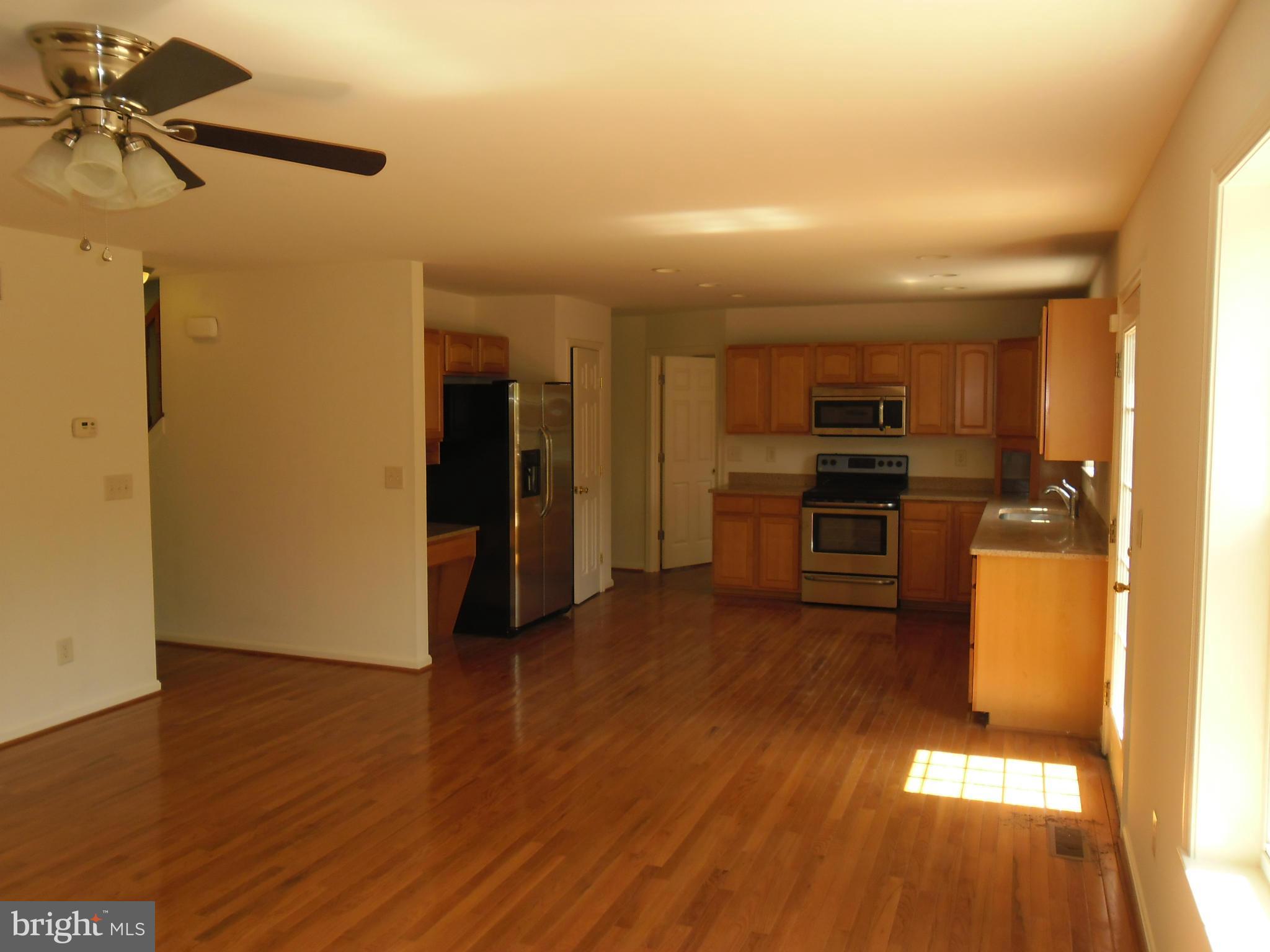 7833 Clark Station Road Severn, MD 21144 - Photo 8 of 30 a view of a kitchen with wooden floor and a refrigerator