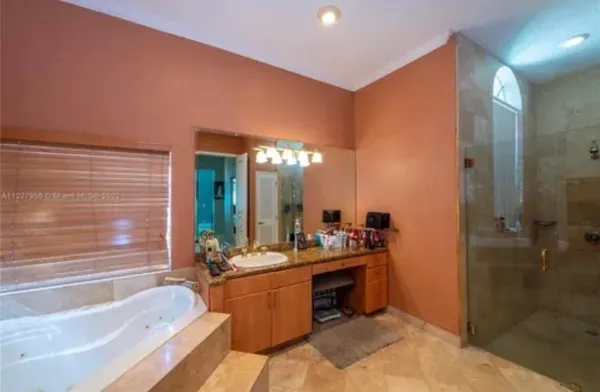 a bathroom with a tub sink shower and mirror