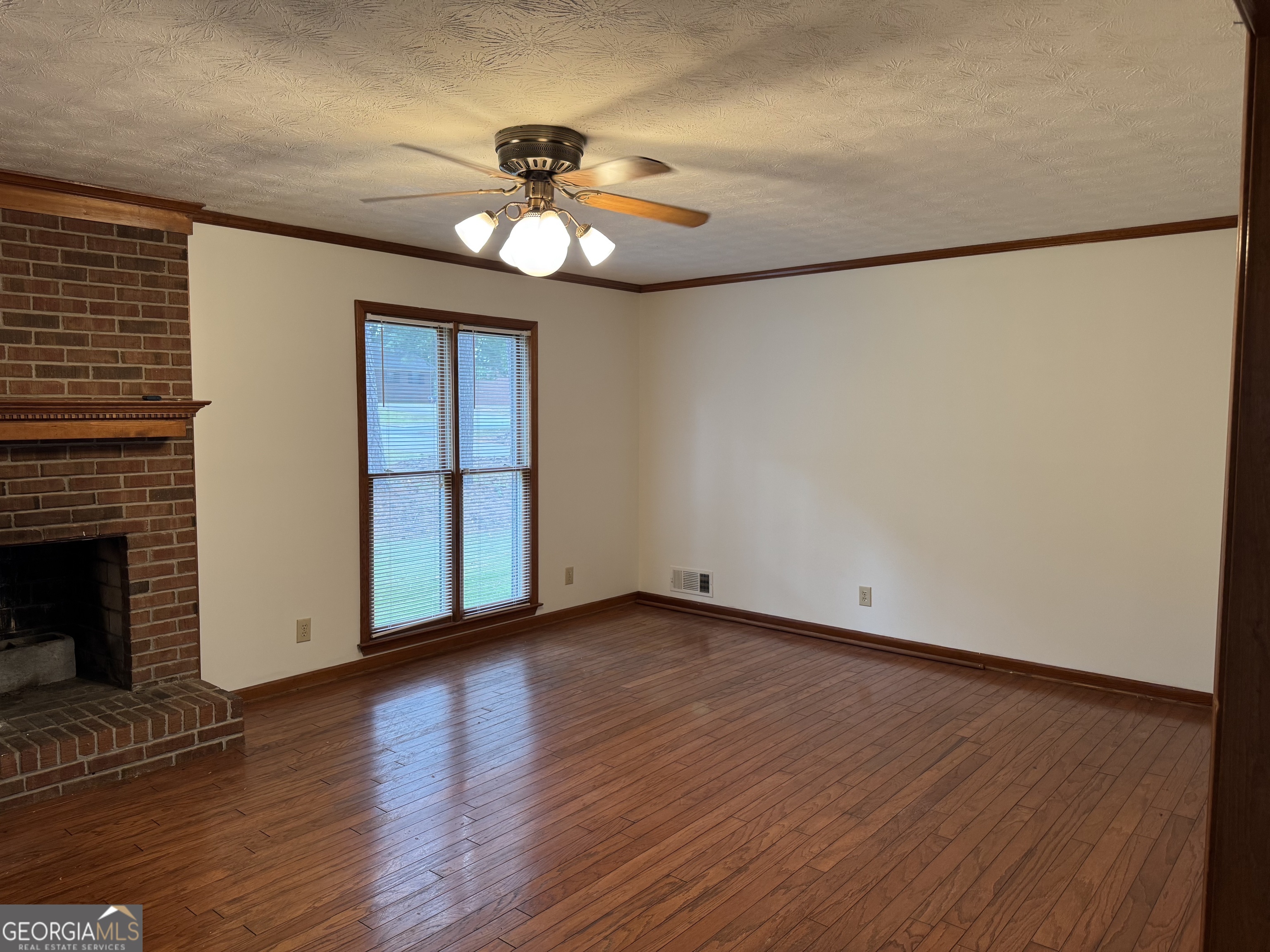 19 Sentry Oak Court, Unit B Stockbridge, GA 30281 - Photo 4 of 14 a view of an empty room with wooden floor and a fireplace