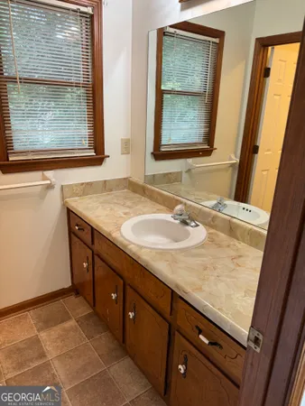 a bathroom with a granite countertop sink and a mirror