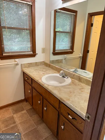 a bathroom with a granite countertop sink and a mirror