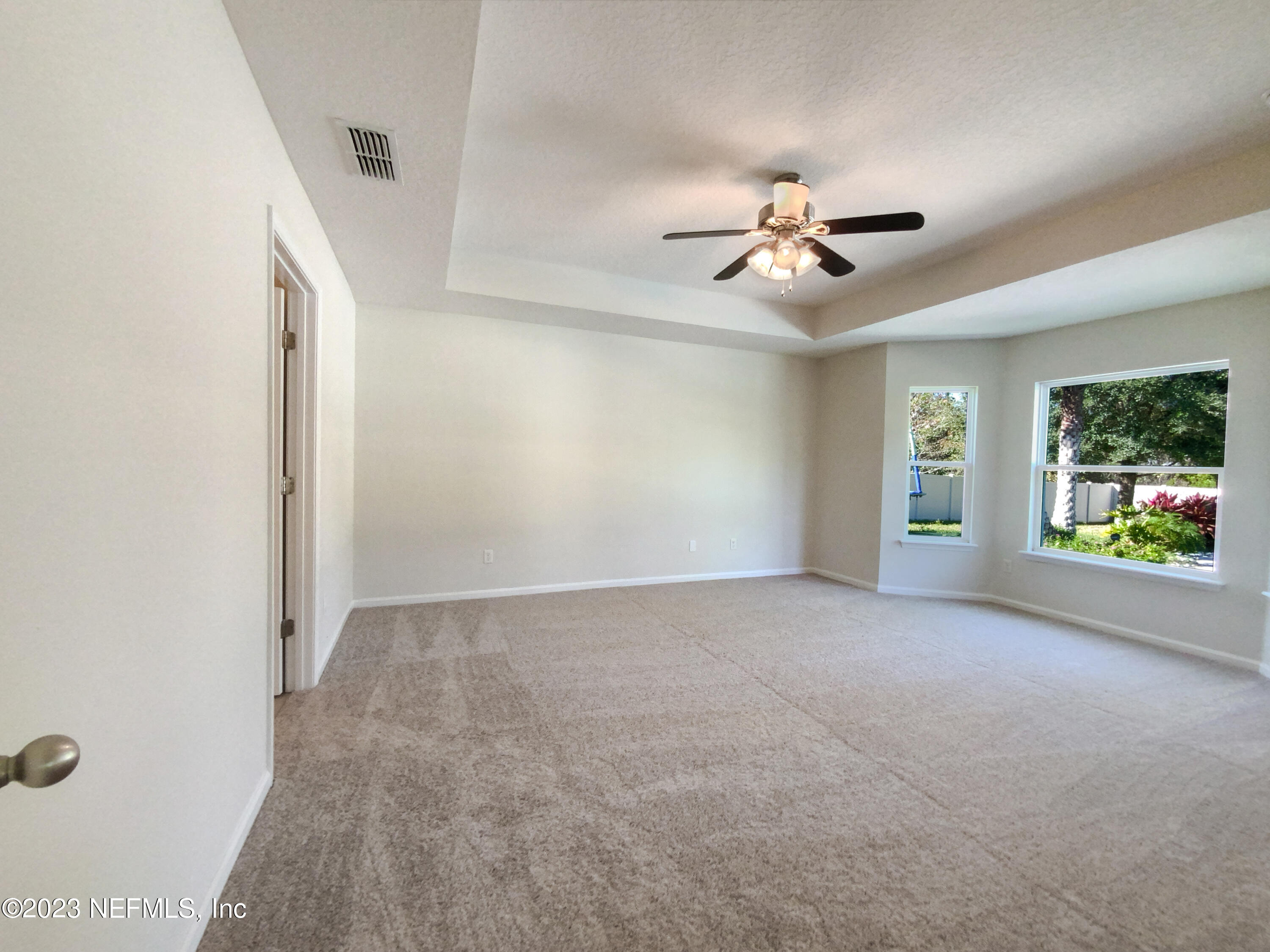 56 Irish Rose Road St. Augustine, FL 32092 - Photo 5 of 25 an empty room with chandelier fan and windows